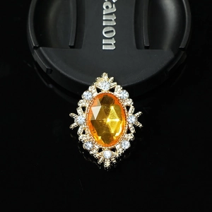 Macro shot of Victorian vintage brooch with oval orange zircon and gold alloy setting