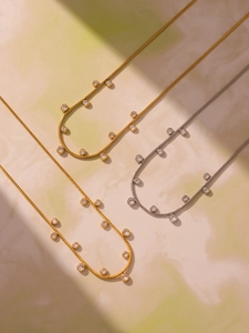 Détail de colliers en maille serpent plaqué or et argent avec pierres de zircon serties