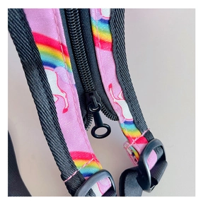 Detalle de mochila rosa de unicornio mostrando cremallera negra y correa de nailon