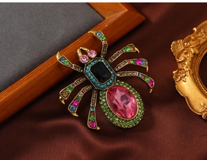 Macro view of vintage spider brooch with pink crystal and colorful rhinestone setting