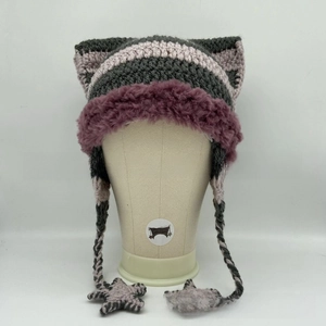 Detail of hand-knitted cat ear hat with star fringe and purple faux fur brim