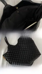 Detail view of the interior zip pocket and quilted diamond texture on the black tote bag