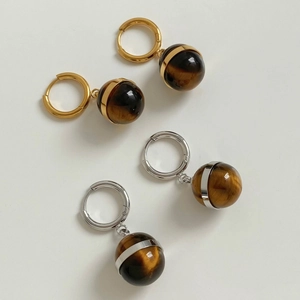 Detail of tiger eye stone pendant earrings in gold and silver metal hoop finishes