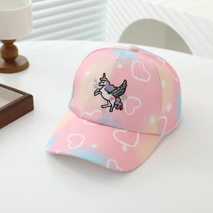 Dettaglio del ricamo di unicorno e stelle d'argento su cappello bambino rosa e blu