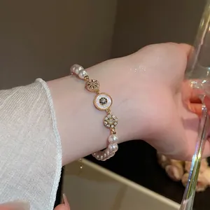 Bracelet de perles plaqué or 18k avec œil de zircon bleu et breloques étoiles au poignet
