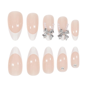 Uñas postizas de almendra rosa nude con lazos plateados 3D y detalles de perlas