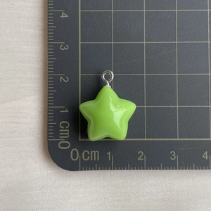 Detailed scale measurement of a green resin star charm with a silver loop connector