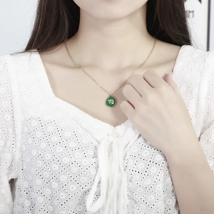 Close-up of gold Virgo constellation necklace with green malachite pendant and rhinestones