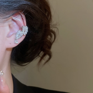 Close-up of a silver leaf ear cuff featuring shimmering cubic zirconia on model's ear