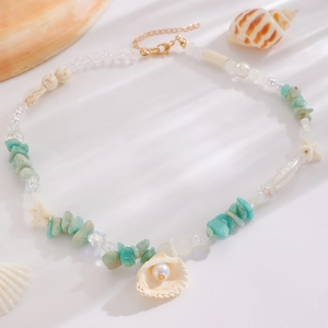 Detail of beach style necklace featuring turquoise stone chips, shells, and pearls