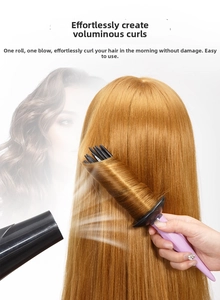 Detail of a purple volumizing hair roller brush lifting hair roots for wavy styling