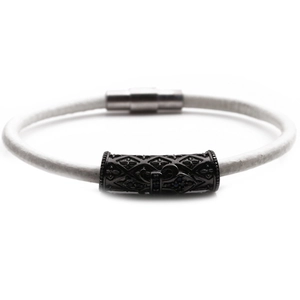 Close-up of a white leather cord bracelet with a black metal cross and magnetic clasp