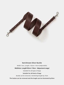 Detail of dark brown leather handbag strap with silver lobster clasp and metal rivets