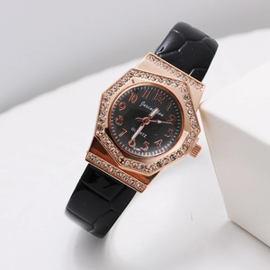 Detail of rose gold octagonal watch case with diamond inlay and black embossed strap