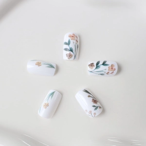 Floral press-on nails with hand-painted pink flowers and green leaves on white base