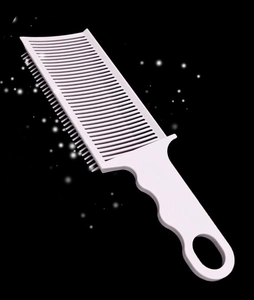 Gros plan d'un peigne de coiffure incurvé rose clair pour dégradés et coiffage pro