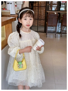 Detail of yellow handheld bag with green trim and metallic butterfly decor for girls