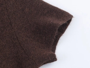 Close-up of dark brown knit texture and plush faux fur material of the dress set