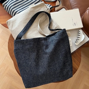 Close-up of navy herringbone canvas tote bag showing the texture and simple wish side label
