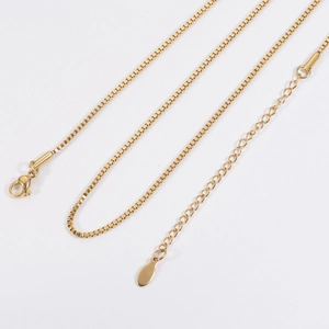Golden stainless steel box chain detail showing lobster clasp and extension link