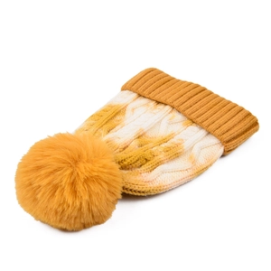 Detailed cable knit pattern on a yellow and white tie-dye beanie with faux fur pom-pom