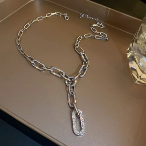 Détail d'un collier argenté à gros maillons orné de zircons sertis en pavé brillant