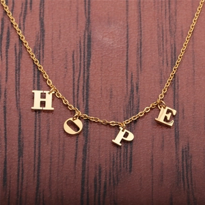Collier en acier inoxydable doré avec pendentifs lettres HOPE sur fond de bois