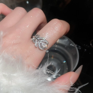 Macro dell'anello in argento a piuma con micro-pave di zirconi e diamante centrale rotondo