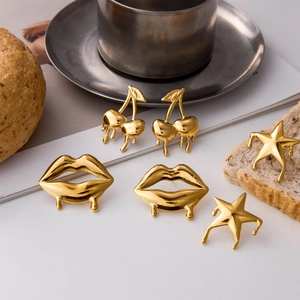 Detail of gold cherry lip and star studs with liquid metal finish on a tabletop