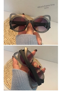 Close-up of cat-ear shaped children sunglasses with black glitter frames and gray lenses
