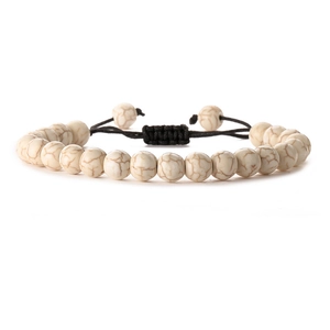 Detailed view of white turquoise beads with black braided cord and adjustable knot