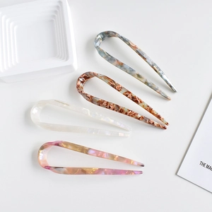 Minimalist U-shaped acetate hairpins in marble and leopard patterns on a white tray
