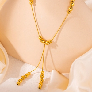 Elegant gold titanium steel Y-shaped necklace with polished bead tassels and silk background