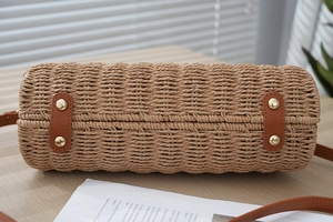 Close-up of handwoven beach bag base with brown leather pads and gold metal rivets