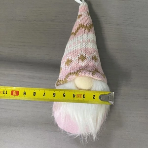 Dettaglio dello gnomo natalizio in maglia rosa con righello che misura 10 cm di larghezza
