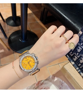Gros plan d'une montre à quartz pour femme avec cadran orange et bracelet en silicone