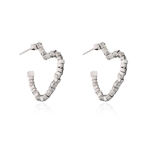Detailed view of silver heart-shaped geometric stud earrings with polished metallic finish