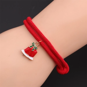 Detail of red woven Christmas bracelet with alloy bell charms on a person's wrist