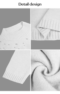 Détail de la robe en maille blanche avec col rond côtelé et ornements de perles fines