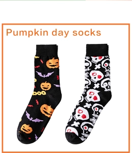 Detail of Halloween socks with pumpkin bat and skull patterns on white background