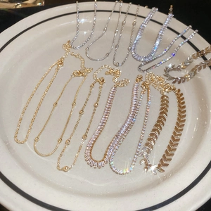 Detail view of various sparkling zircon bracelets in gold and silver on a ceramic tray