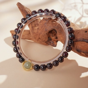 Vue macro détaillée de perles de grenat et d'une pierre de jade sur un bracelet perlé