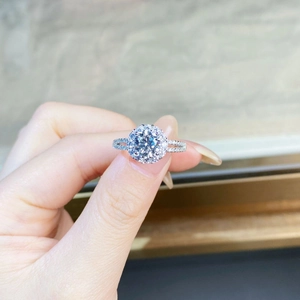 Macro shot of 925 silver ring featuring a 1ct round moissanite with halo setting on finger