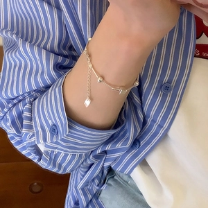 Silver bead and tube link bracelet with a delicate heart charm on woman wrist
