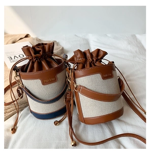 Retro canvas bucket bag with leather trim and drawstring closure in soft light