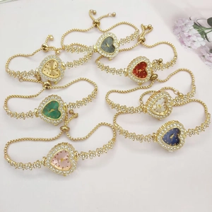 Flat lay of colorful heart-shaped gold watches with diamond bezels and sliding bracelets
