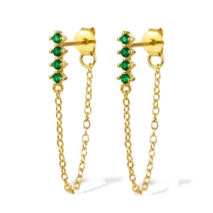Macro detail of gold chain drop earrings with green zircon stones and tassel design