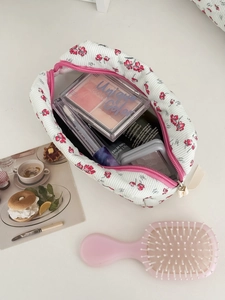 Internal view of floral corduroy makeup bag filled with cosmetics and skincare items