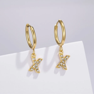 Detail of gold letter X hoop earrings with pavé zircon stones on a geometric stand