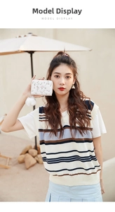 Detailed embroidery on white zip wallet with soft pom-pom charm held by a model